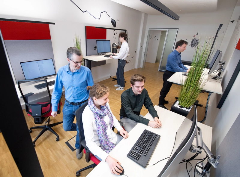 Mitarbeitende im Teamraum während der Arbeit