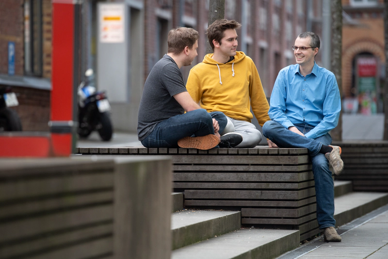 Mitarbeitende in der Pause im Innenhof neben dem Bürogebäude